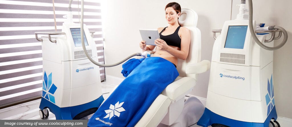 woman sitting receiving CoolSculpting treatment to abdomen